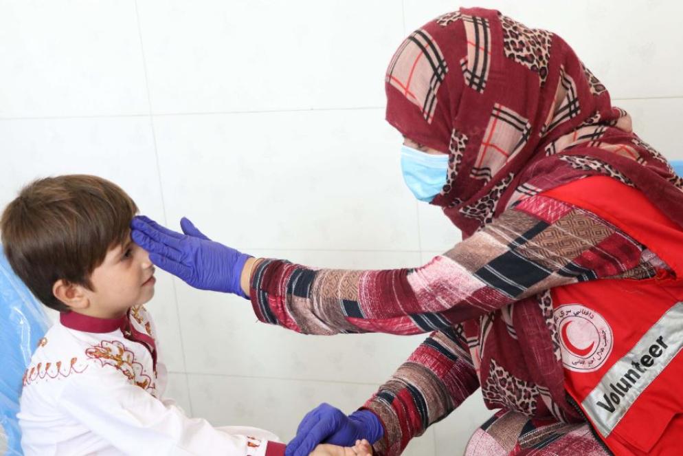 Un'infermiera afghana visita un bambino in un ambulatorio di Kandahr - Ansa