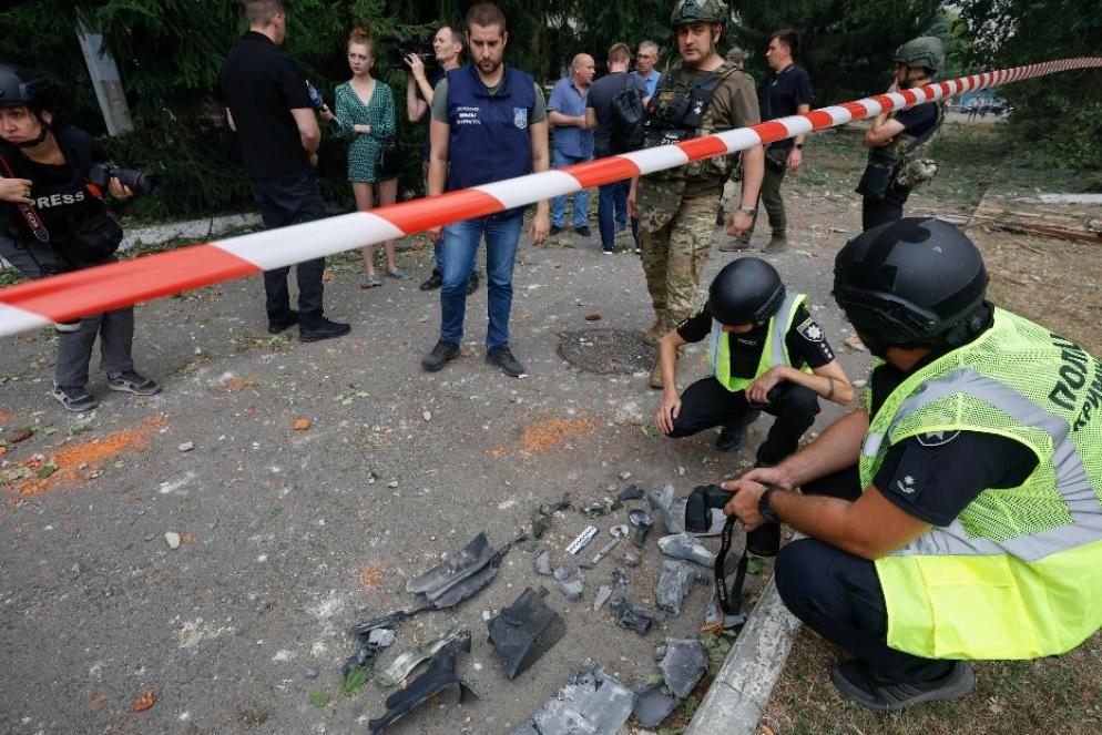 La polizia ucraina mentre raccoglie i resti di un missile russo caduto a Kiev - Ansa