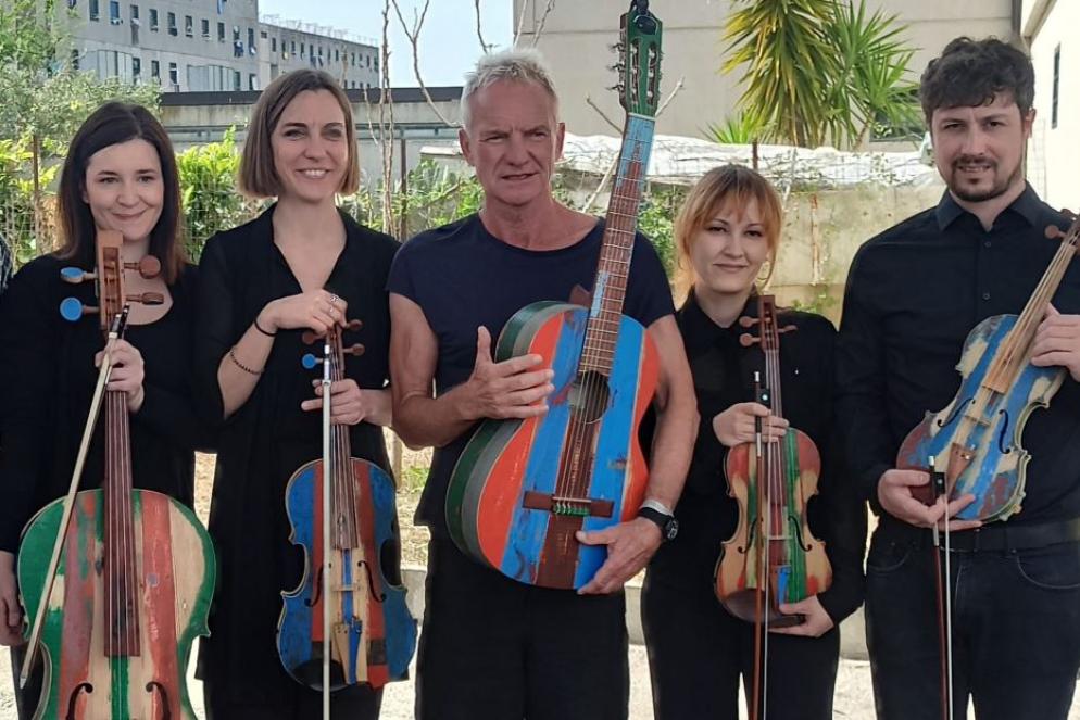 Sting suona nel carcere di Secondigliano, accompagnato da alcuni musicisti - Creata nel carcere di Secondigliano con i legni colorati delle barche dei migranti, suonerà nelle parrocchie di tutto il mondo. La staffetta di pace parte oggi da Milano e raggiungerà ogni nazione