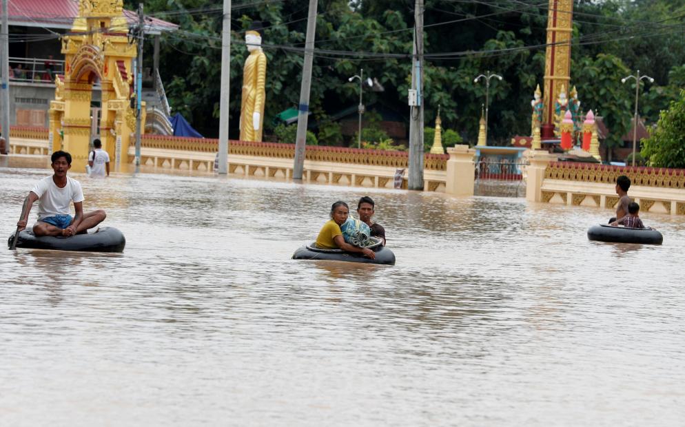 Gli abitanti di Taungoo, nella regione birmana di Bago, cercano di mettersi in salvo "navigando" le acque alluvionali sulle camere d'aria - ANSA