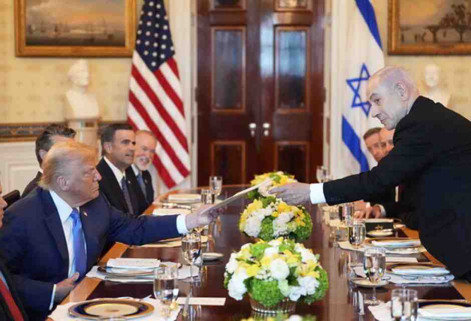 Benjamin Netanyahu consegna una cartella a Donald Trump durante l'incontro nella Sala Blu della Casa Bianca (foto Ap, via LaPresse) <br />