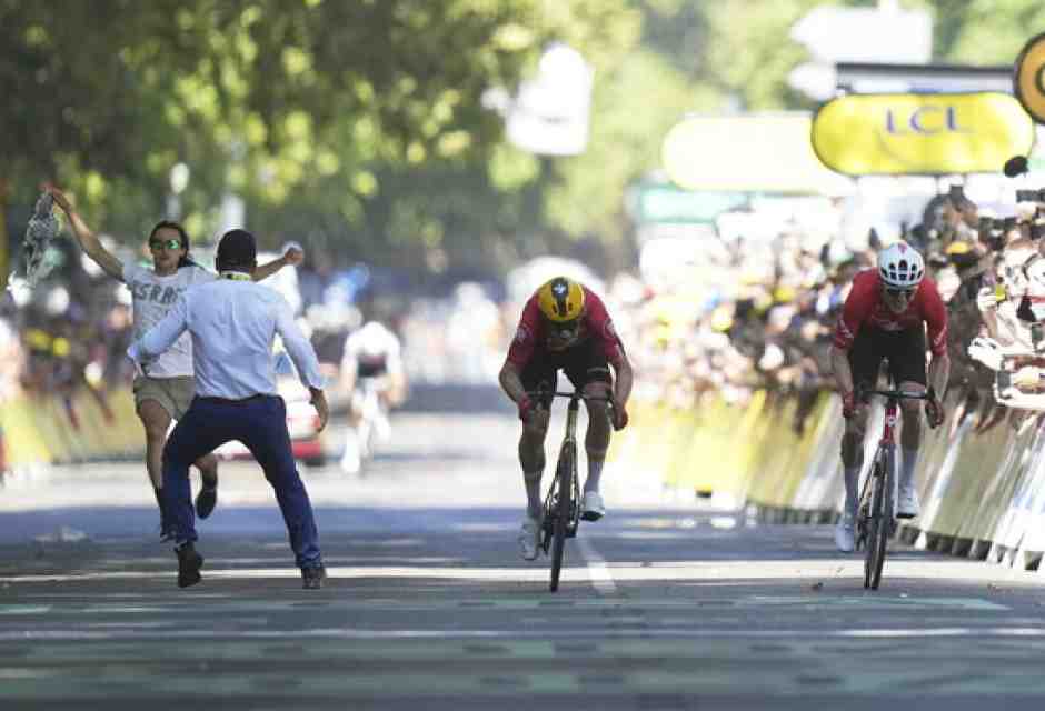 Jonas Abrahamsen, Mauro Schmid e un tizio che protestava per qualcosa sul rettifilo d'arrivo della undicesima tappa del Tour de France 2025 (foto Ap, via LaPresse)&nbsp;