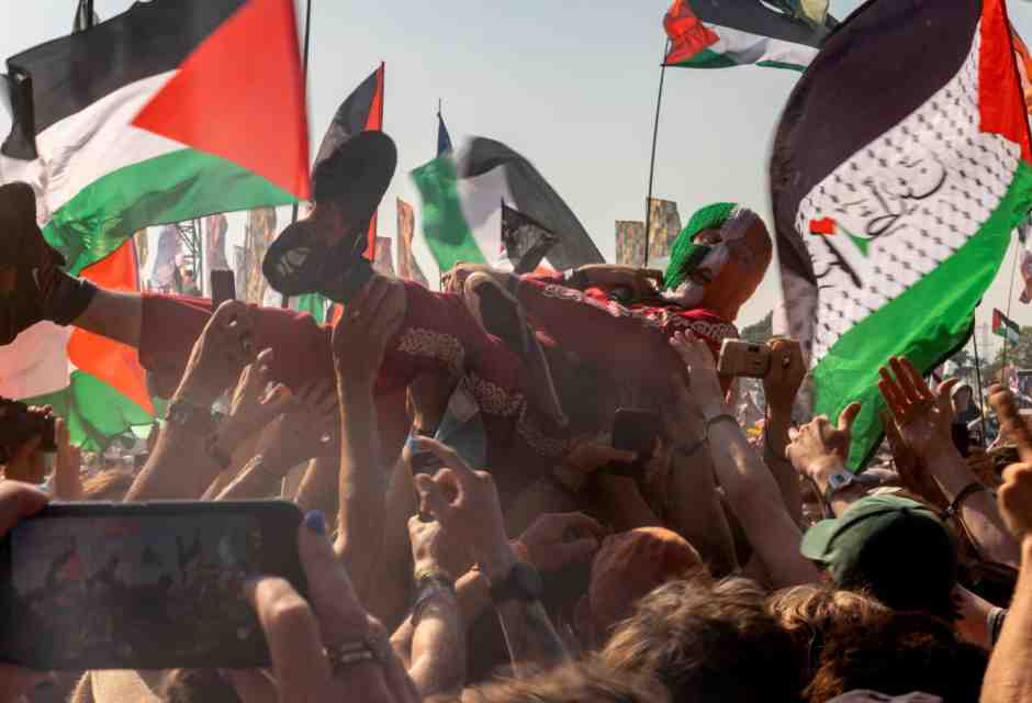 &nbsp;DJ Prova&iacute; del trio hip hop irlandese Kneecap al festival di Glastonbury fra bandiere della Palestina (foto Getty)<br />